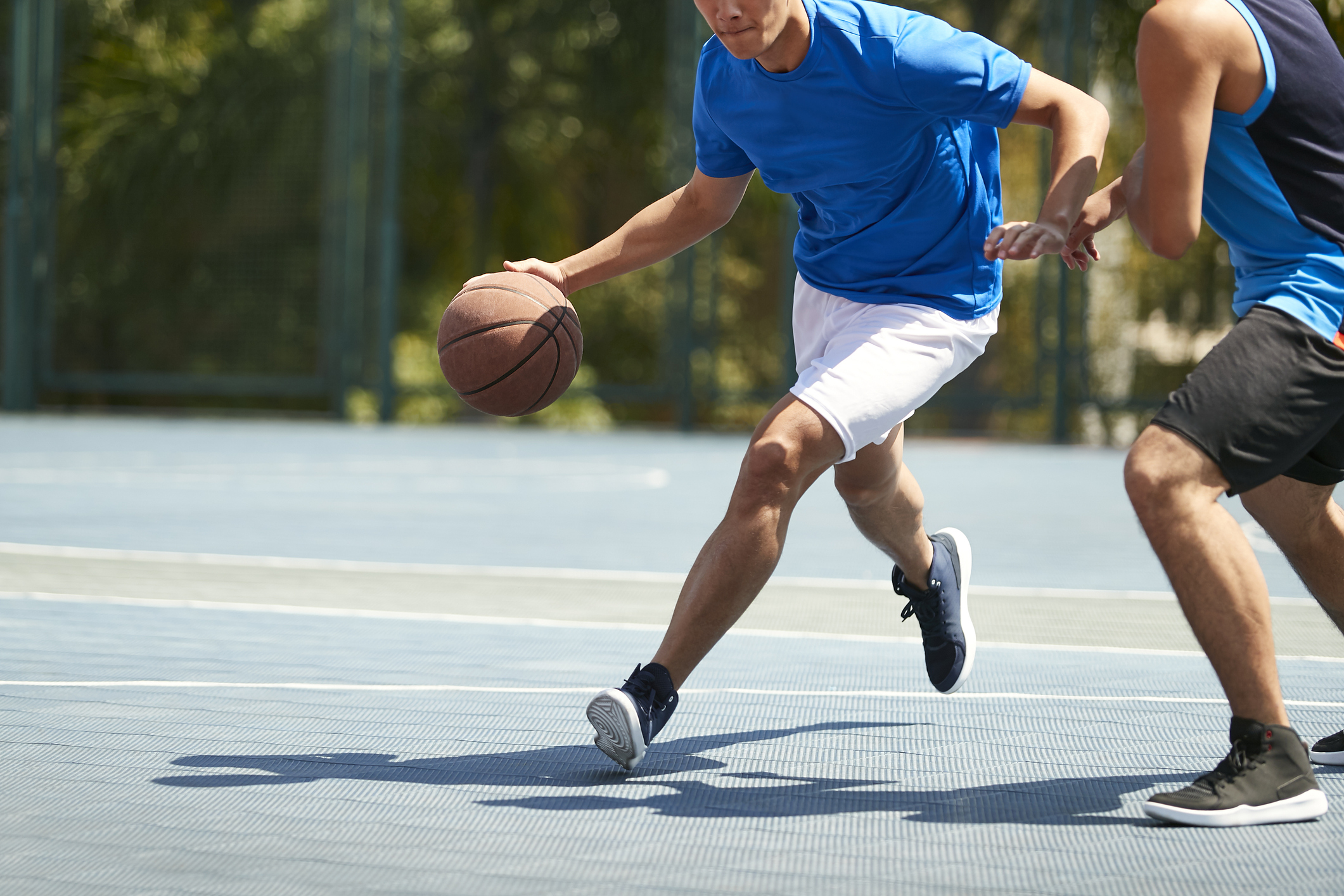 Young people playing basketball outdoors